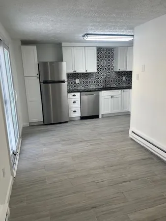 a kitchen with granite countertop a refrigerator and a sink