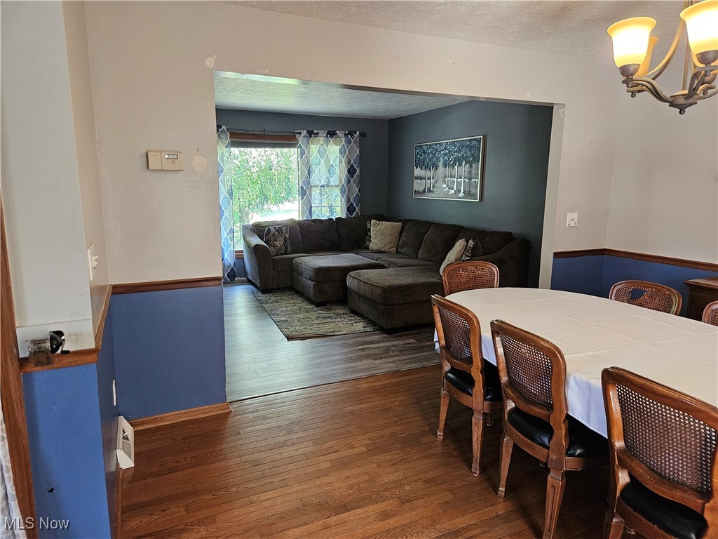6247 Hathaway Road Cleveland, OH 44125 - Photo 18 of 42 Dining area featuring hardwood / wood-style flooring, a chandelier, and a textured ceiling