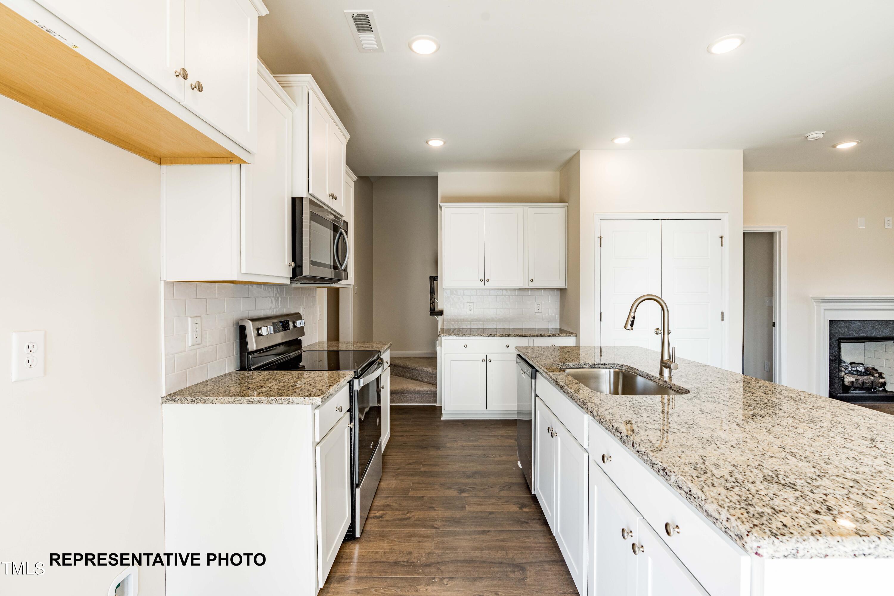 112 Springtooth Drive Zebulon, NC 27597 - Photo 4 of 10 a kitchen with stainless steel appliances granite countertop a sink stove and refrigerator