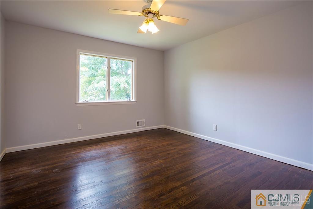 26 Purdue Road Old Bridge, NJ 08859 - Photo 13 of 21 an empty room with wooden floor chandelier fan and windows