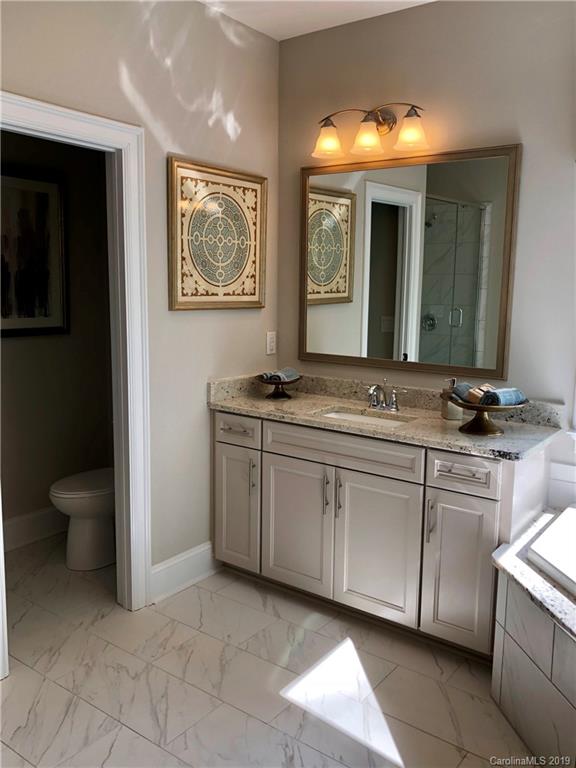 1392 Afton Way, Unit 147 Fort Mill, SC 29708 - Photo 19 of 28 a spacious bathroom with a granite countertop sink and a mirror