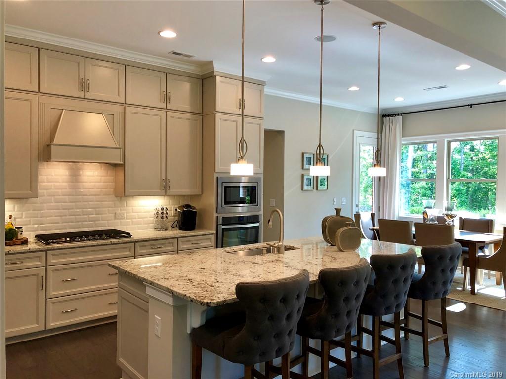 1392 Afton Way, Unit 147 Fort Mill, SC 29708 - Photo 6 of 28 a kitchen with granite countertop a stove a sink a dining table and chairs