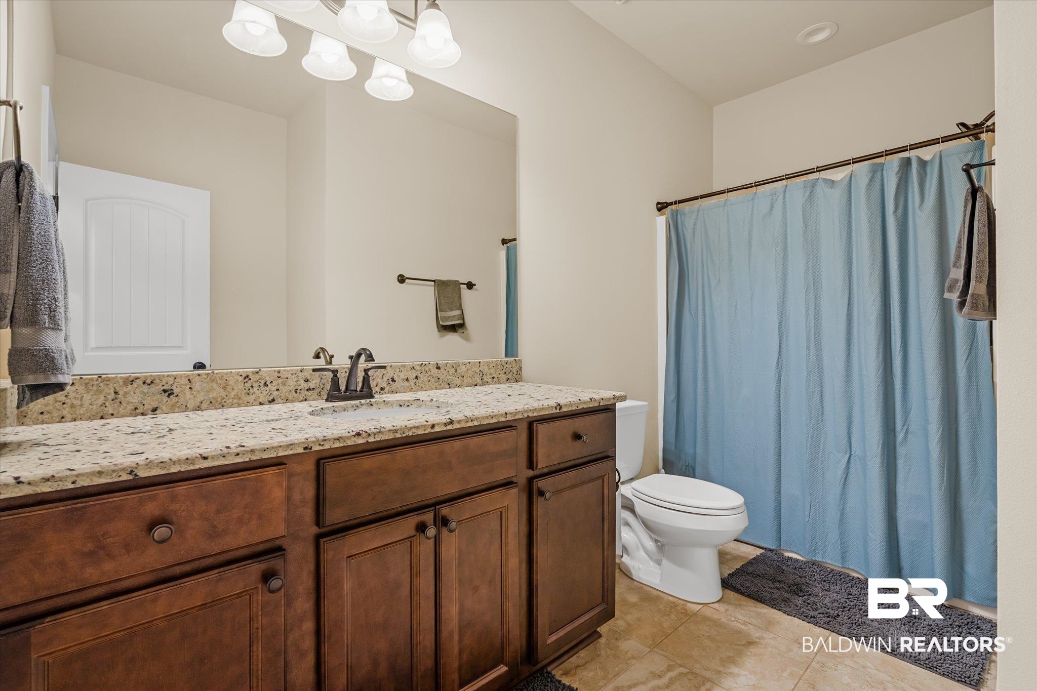 9912 Dunleith Loop Daphne, AL 36526 - Photo 16 of 23 Full bathroom featuring a shower with shower curtain, vanity, and light tile patterned floors