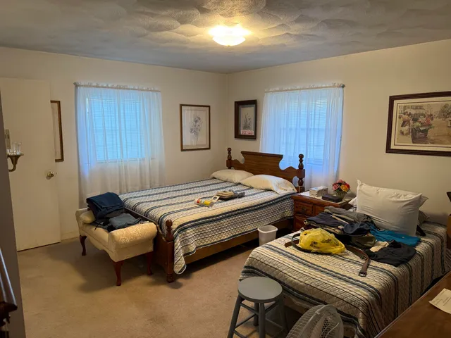 a bedroom with a bed and a refrigerator