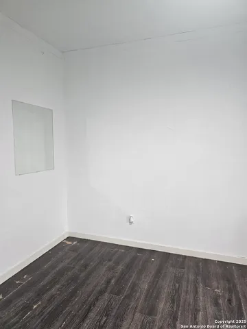 a view of an empty room and wooden floor