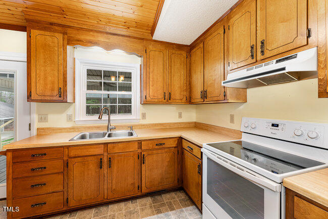 6693 Silk Hope Liberty Road Siler City, NC 27344 - Photo 13 of 32 a kitchen with sink cabinets and window