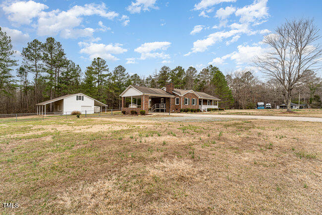 6693 Silk Hope Liberty Road Siler City, NC 27344 - Photo 2 of 32 a house view with swimming pool and trees in the background