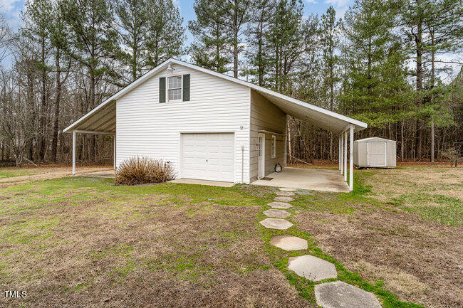 6693 Silk Hope Liberty Road Siler City, NC 27344 - Photo 31 of 32 a backyard of a house with table and chairs