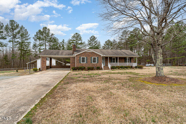 6693 Silk Hope Liberty Road Siler City, NC 27344 - Photo 5 of 32 a front view of a house with a garden