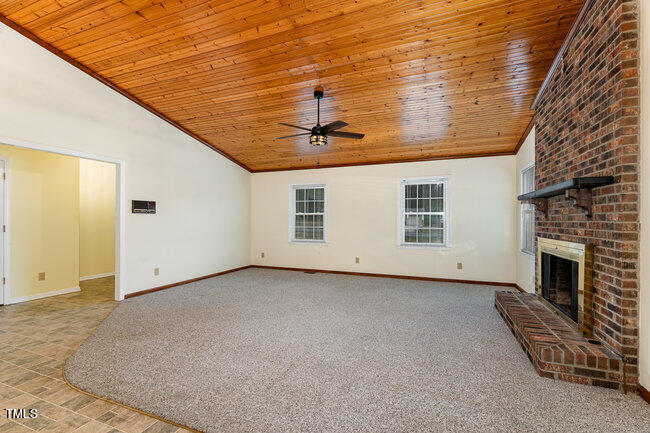6693 Silk Hope Liberty Road Siler City, NC 27344 - Photo 7 of 32 a view of a livingroom with a fireplace and a ceiling fan