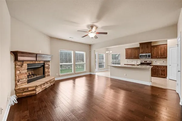 a view of a kitchen with a stove cabinets a fireplace and wooden floor