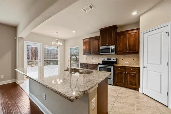 a kitchen with stainless steel appliances granite countertop a stove refrigerator and cabinets