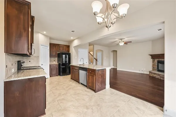 a kitchen with stainless steel appliances granite countertop a refrigerator and a stove top oven