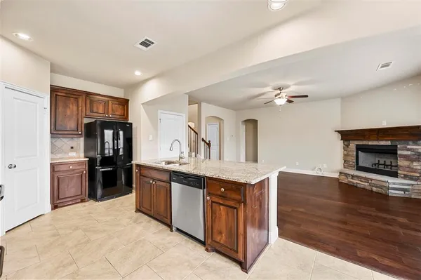 a kitchen with stainless steel appliances granite countertop a stove refrigerator and cabinets