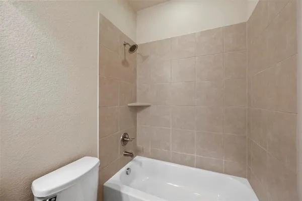 a bathroom with a white bath tub and a toilet