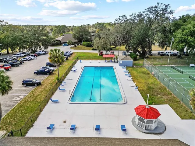 a view of swimming pool with outdoor seating and trees