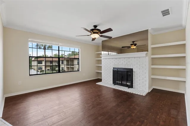 a view of an empty room with a fireplace and a window