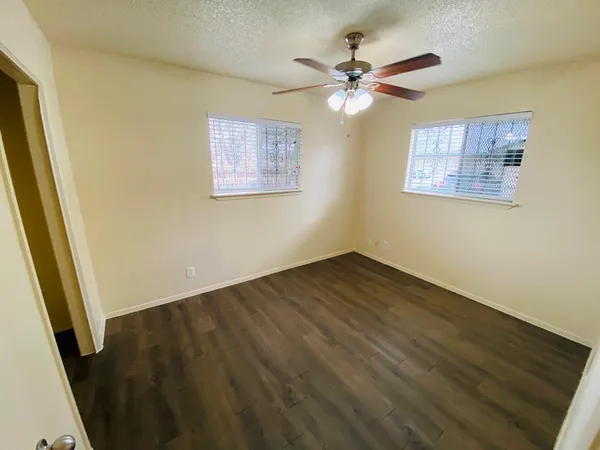 a view of a room with wooden floor and a ceiling fan