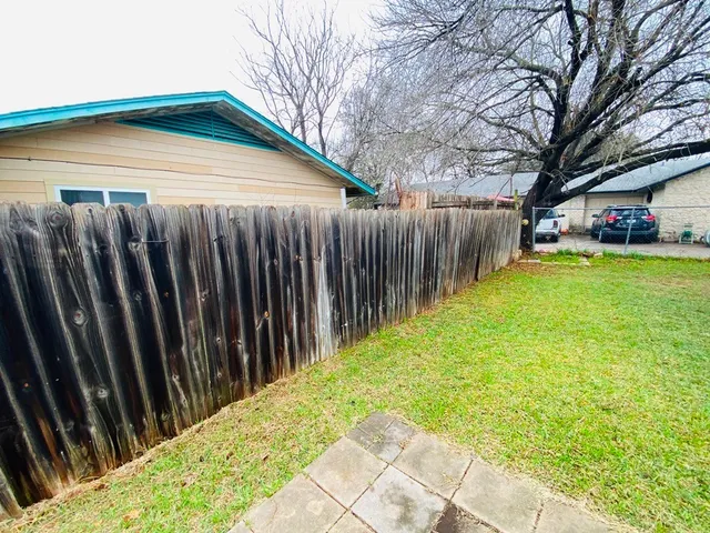 a view of a backyard with wooden fence