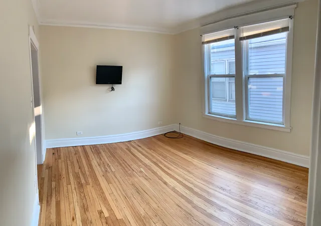a view of a livingroom with wooden floor and a window