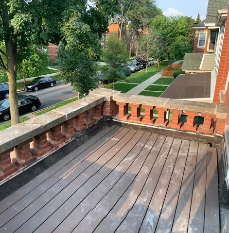a view of a balcony with wooden floor and fence