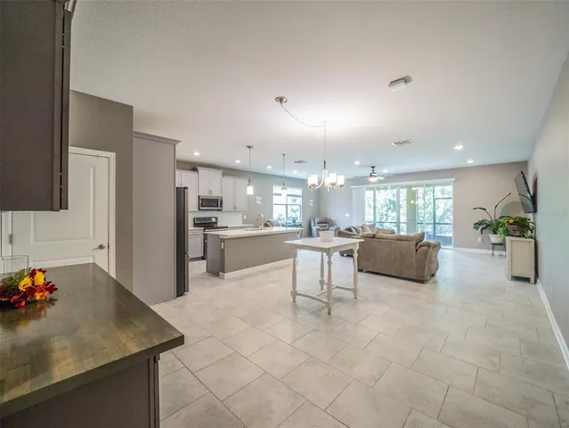 a kitchen with stainless steel appliances kitchen island granite countertop a sink refrigerator and cabinets