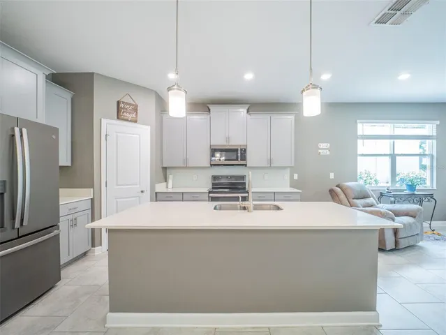a kitchen with stainless steel appliances granite countertop a sink and a refrigerator
