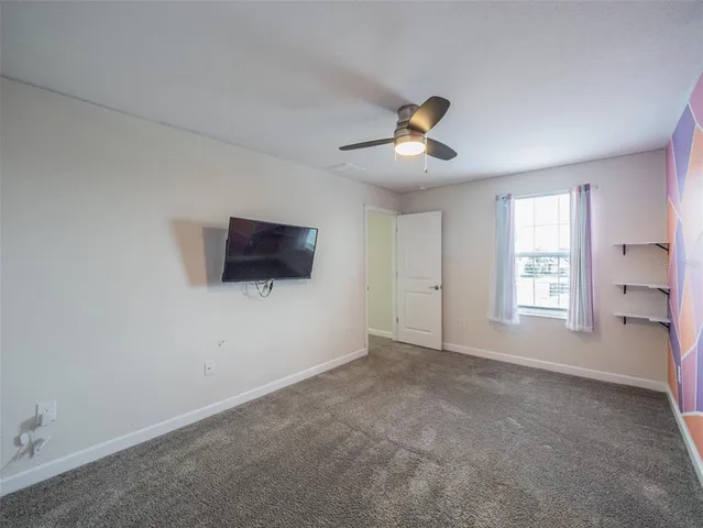 an empty room with a window and ceiling fan