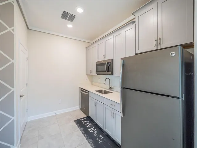 a kitchen with stainless steel appliances a refrigerator a sink a stove a microwave and cabinets