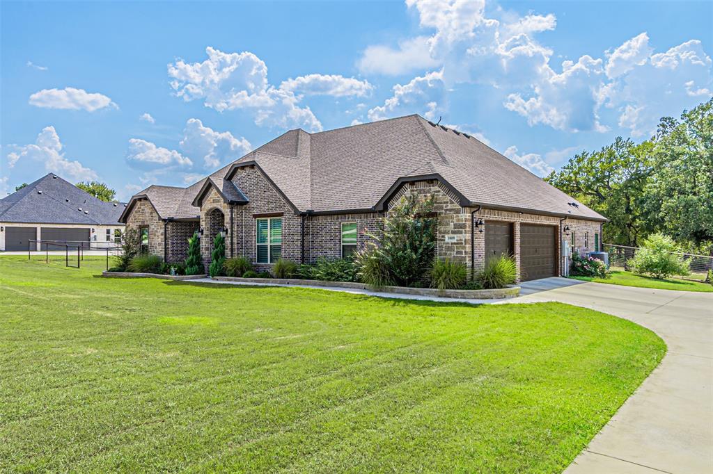 1009 Henry Way Springtown, TX 76082 - Photo 2 of 40 French country style house featuring driveway, brick siding, a garage, and roof with shingles