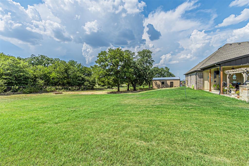 1009 Henry Way Springtown, TX 76082 - Photo 40 of 40 View of green lawn with a patio area and an outbuilding