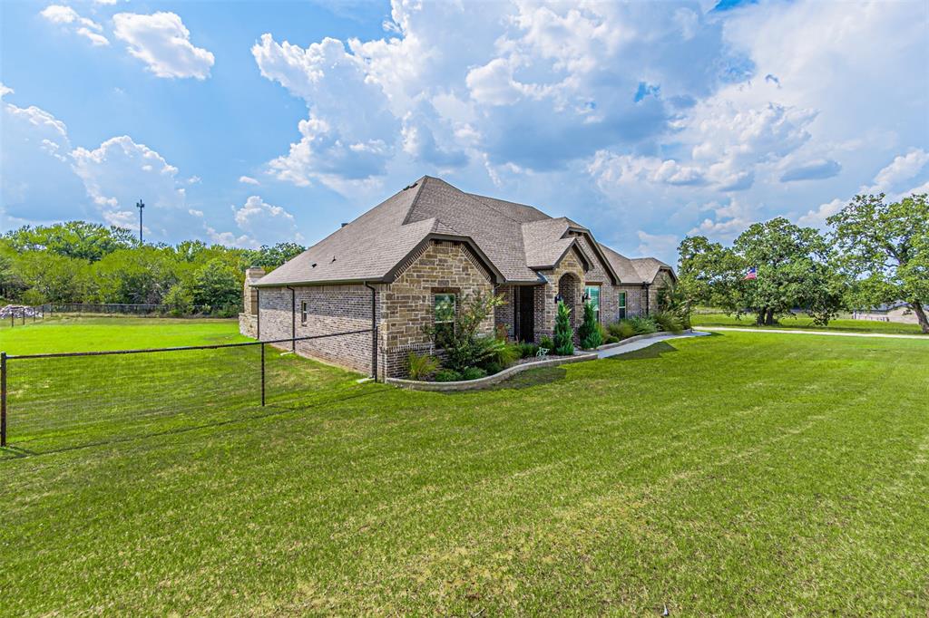 1009 Henry Way Springtown, TX 76082 - Photo 4 of 40 French country style house featuring stone siding, a front yard, and a shingled roof