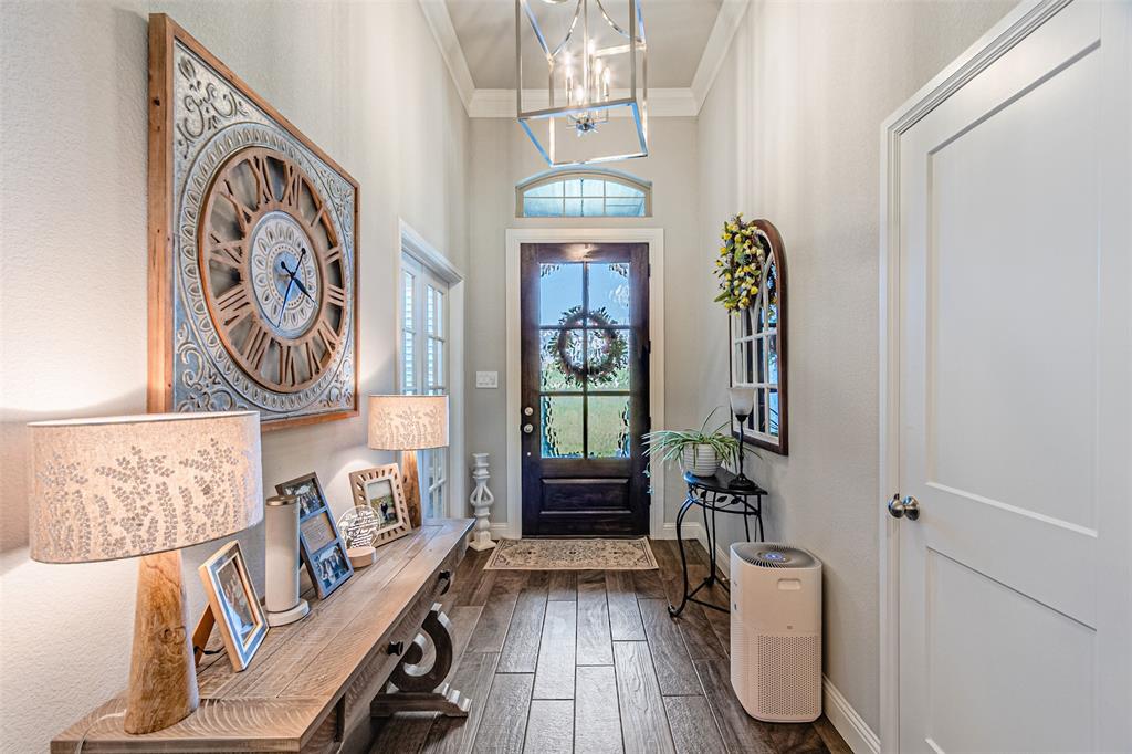 1009 Henry Way Springtown, TX 76082 - Photo 6 of 40 Foyer entrance with crown molding, a chandelier, and dark wood-style flooring