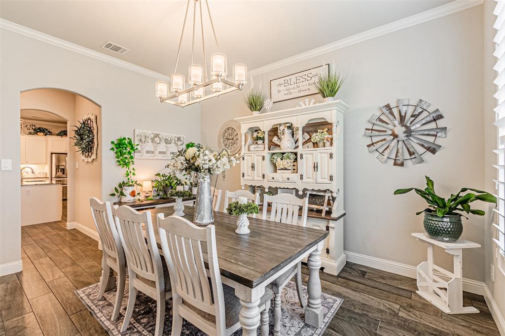 1009 Henry Way Springtown, TX 76082 - Photo 8 of 40 Dining area with arched walkways, ornamental molding, dark wood-style flooring, and a chandelier