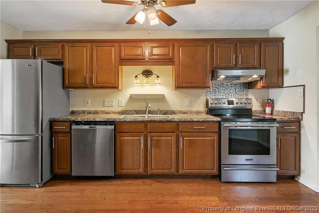 6875 Baystone Road Fayetteville, NC 28314 - Photo 17 of 50 a kitchen with granite countertop stainless steel appliances and wooden cabinets