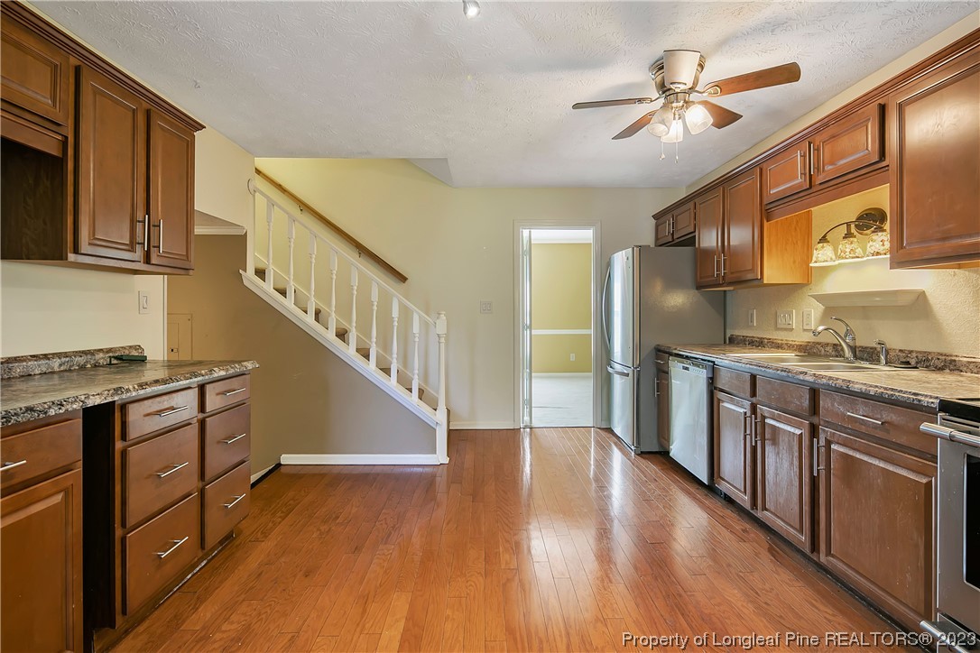 6875 Baystone Road Fayetteville, NC 28314 - Photo 19 of 50 a kitchen with stainless steel appliances granite countertop a sink a stove a refrigerator cabinets and wooden floor