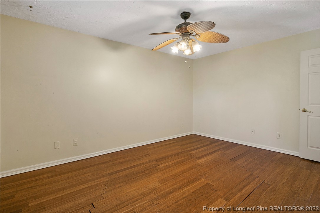 6875 Baystone Road Fayetteville, NC 28314 - Photo 30 of 50 an empty room with wooden floor and chandelier