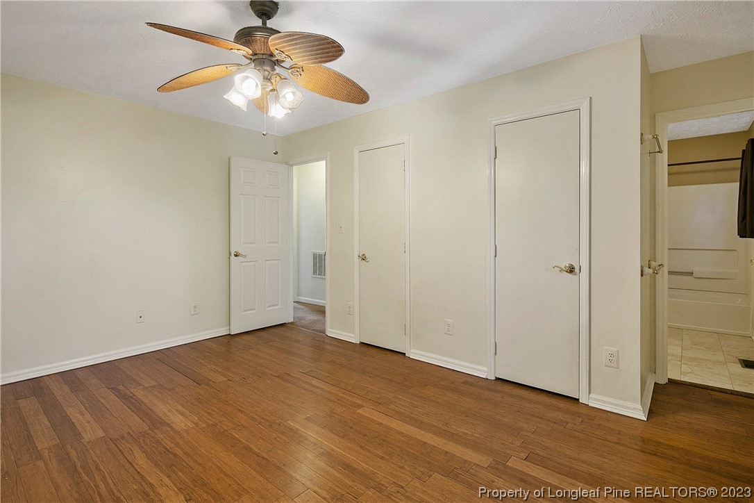 6875 Baystone Road Fayetteville, NC 28314 - Photo 31 of 50 a view of an empty room with chandelier fan and wooden floor