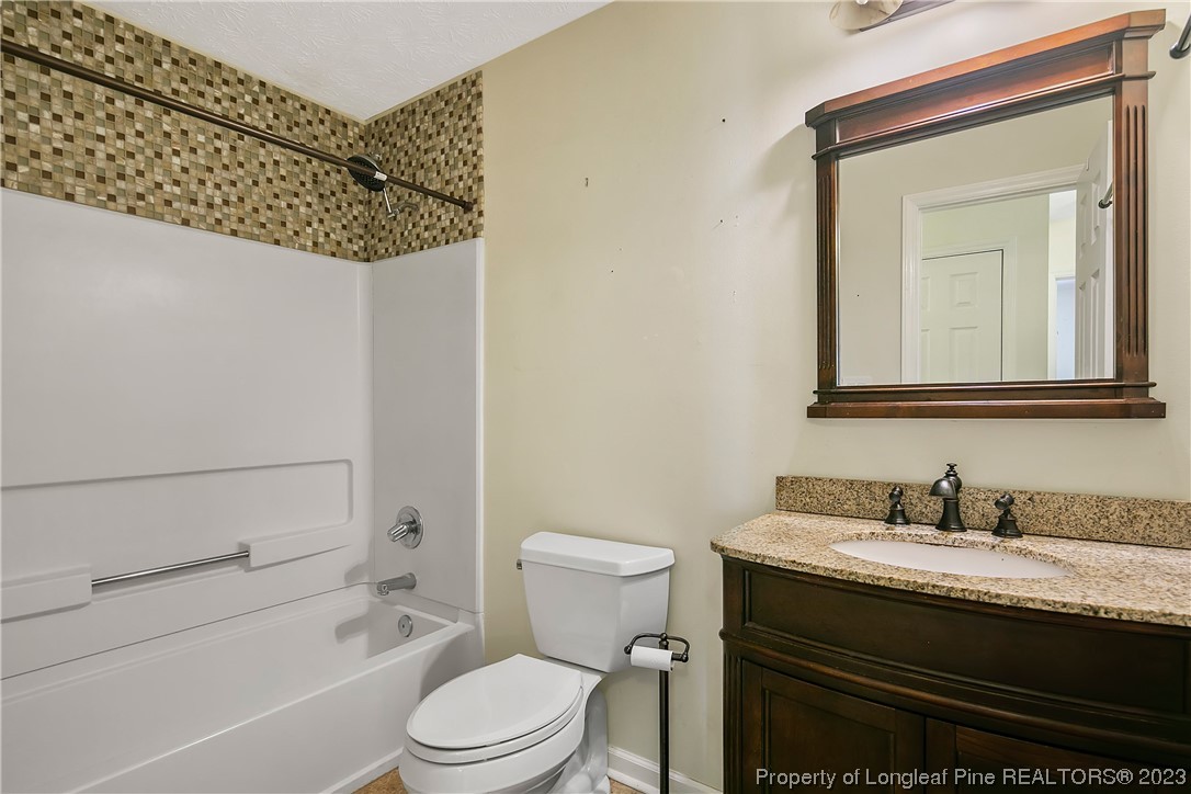 6875 Baystone Road Fayetteville, NC 28314 - Photo 39 of 50 a bathroom with a granite countertop sink toilet and shower