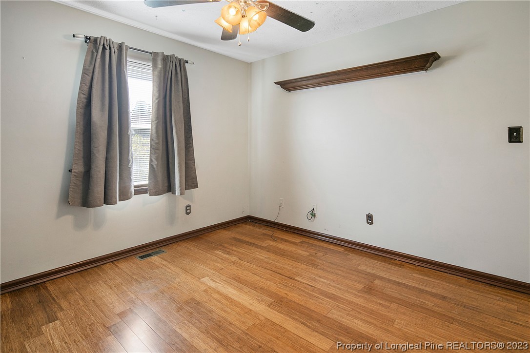 6875 Baystone Road Fayetteville, NC 28314 - Photo 42 of 50 a view of an empty room with wooden floor and a window