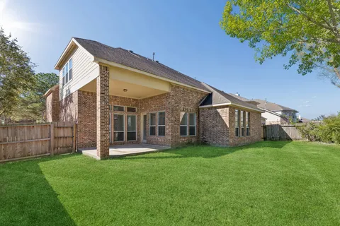 a view of a house with a yard and large tree