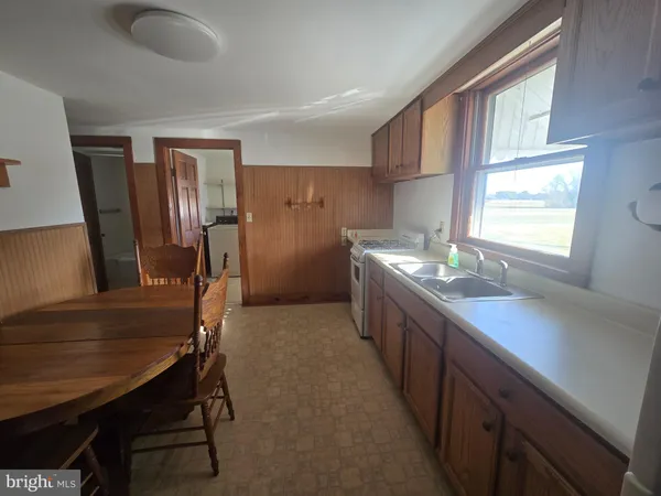 a kitchen with a table chairs sink stove and refrigerator