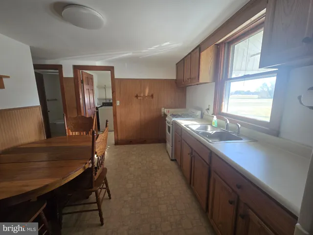 a kitchen with a table chairs sink stove and refrigerator