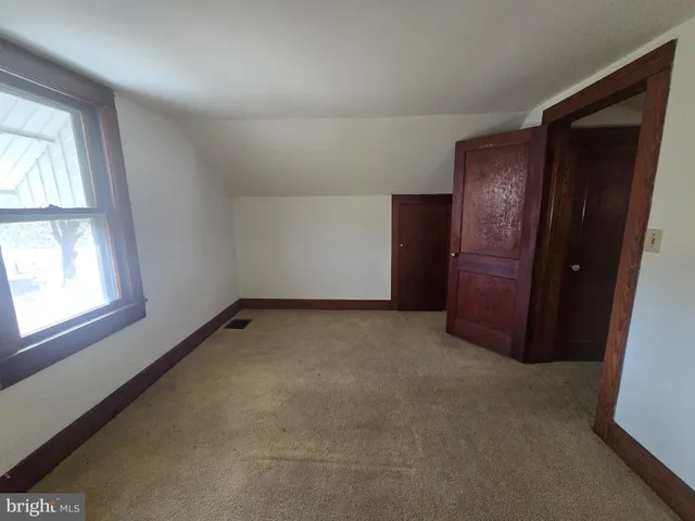 an empty room with windows and closet