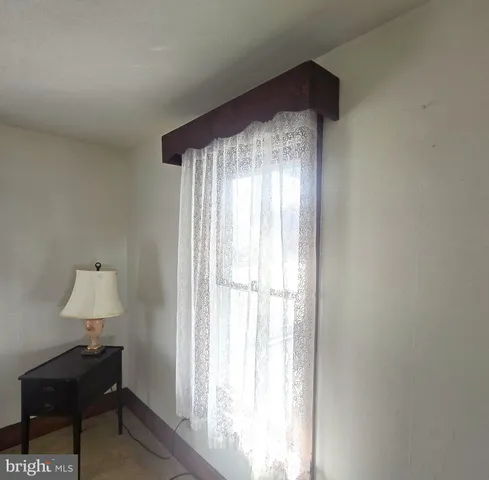 a view of empty room with a window and a lamp