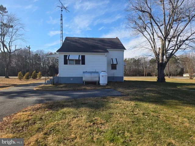 a front view of a house with a yard and trees