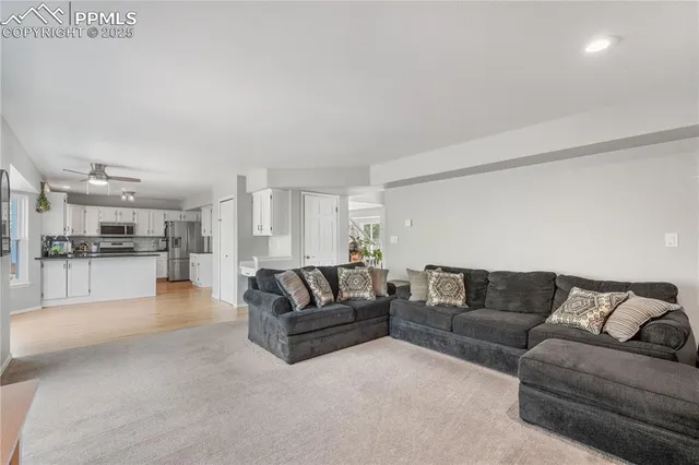 a living room with furniture and view of kitchen