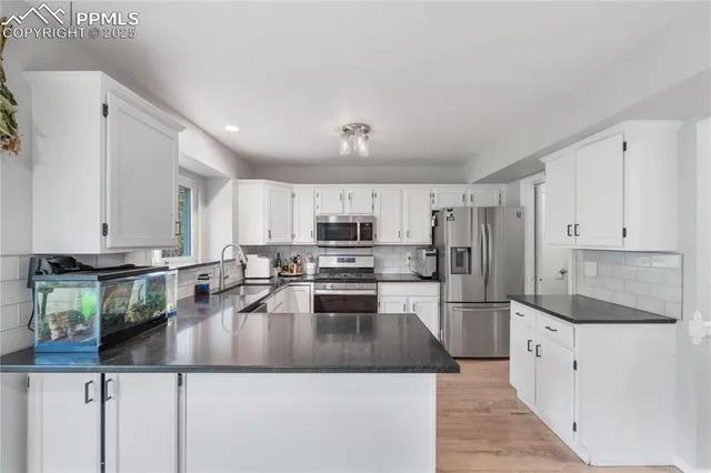 a kitchen with a refrigerator a stove a sink a counter top space and cabinets