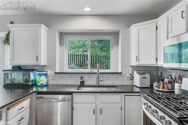 a kitchen with granite countertop white cabinets and a window