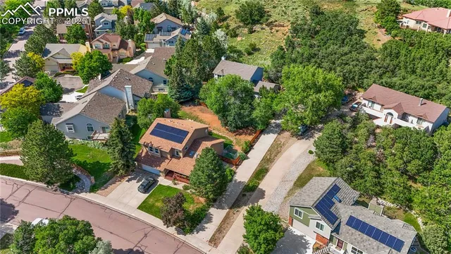 an aerial view of a residential apartment building with a yard and parking spaces
